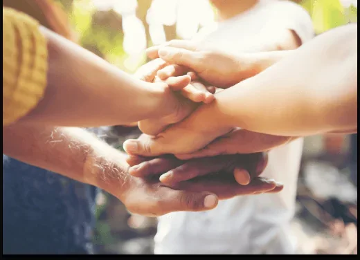 Volunteers joining hands together